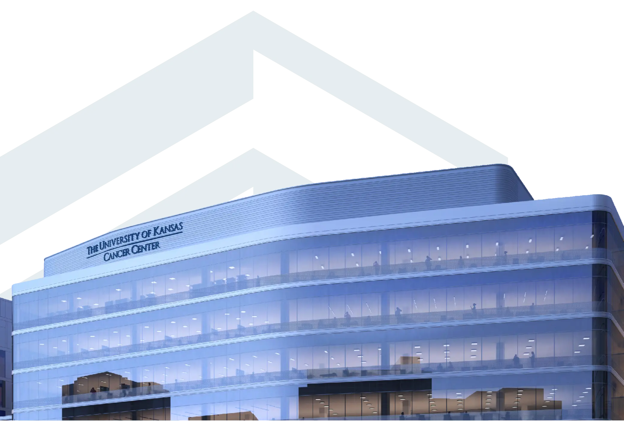 Modern multi-story glass building with illuminated interior and a sign reading “The University of Kansas Cancer Center” near the roofline.
